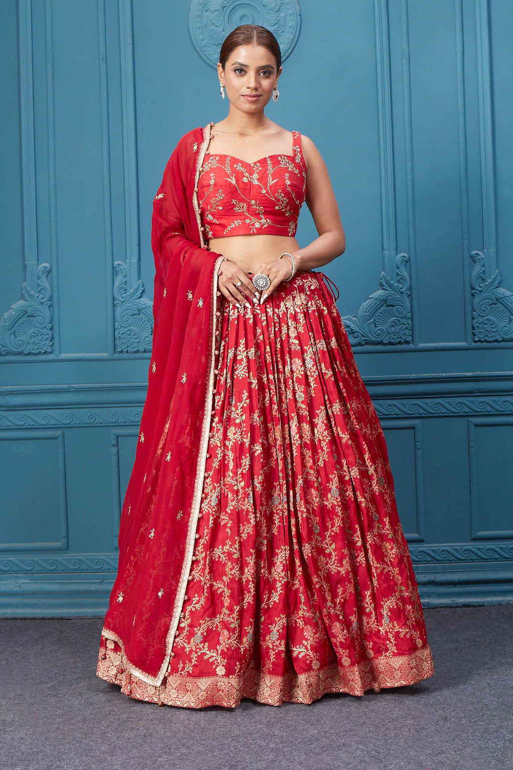 Shop this red lehenga with golden embroidery. Dazzle on weddings and special occasions with exquisite Indian designer dresses, sharara suits, Anarkali suits, bridal lehengas, and sharara suits from Pure Elegance Indian clothing store in the USA. Shop online from Pure Elegance.