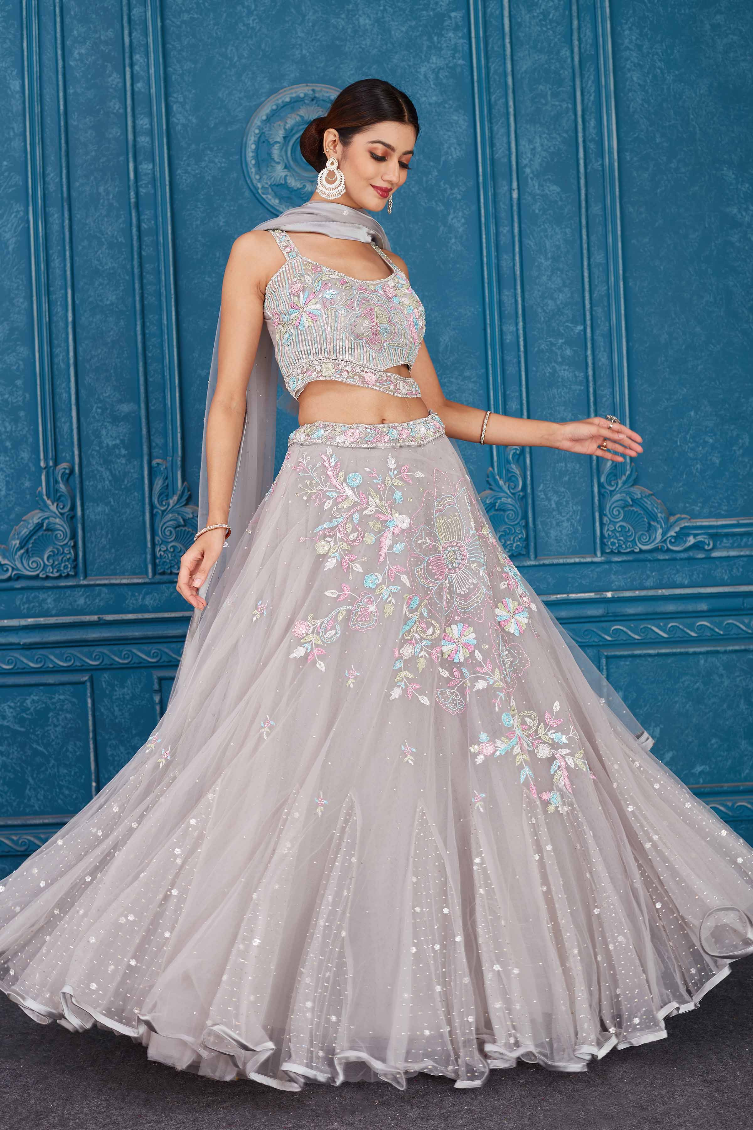 Shop light grey embroidered net lehenga online in USA with dupatta. Slay in style at wedding festivities in this beautiful designer lehengas. hand embroidered lehengas, Bollywood lehenga, Anarkali suits, sharara suits from Pure Elegance Indian saree store in USA. -side