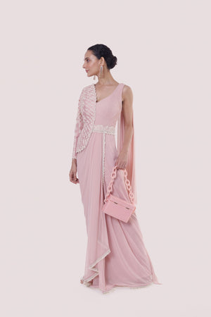 Shop a light pink drape saree set with a faux jacket. Make a fashion statement on festive occasions and weddings with designer sarees, designer suits, Indian dresses, Anarkali suits, palazzo suits, designer gowns, sharara suits, and embroidered sarees from Pure Elegance Indian fashion store in the USA.
