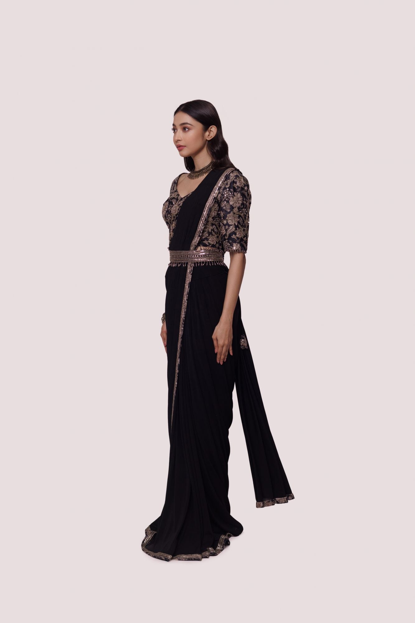 Shop black net saree with embroidered edges and a narrow belt. Make a fashion statement on festive occasions and weddings with designer sarees, designer suits, Indian dresses, Anarkali suits, palazzo suits, designer gowns, sharara suits, and embroidered sarees from Pure Elegance Indian fashion store in the USA.