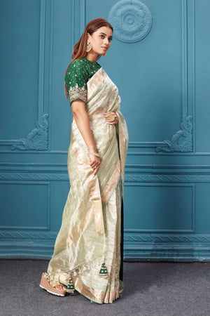 Shop golden green organza silk saree online in USA with embroidered green blouse. Look royal at weddings and festive occasions in exquisite designer sarees, handwoven sarees, pure silk saris, Banarasi sarees, Kanchipuram silk sarees from Pure Elegance Indian saree store in USA. -side