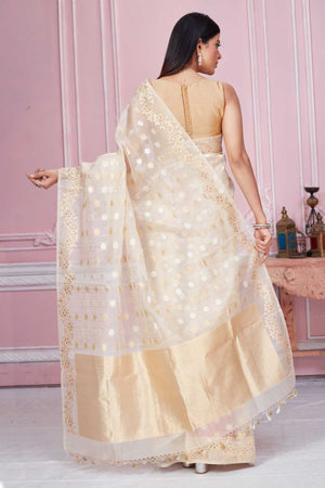 Shop cream Banarasi saree online in USA with scattered buti and zari border. Look your best on festive occasions in latest designer saris, pure silk sarees, Kanjivaram silk sarees, handwoven saris, tussar silk sarees, embroidered saris from Pure Elegance Indian fashion store in USA.-back