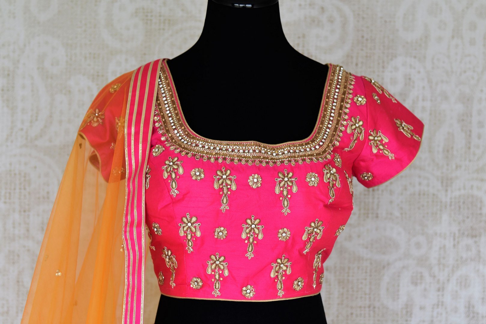 Leave them spellbound as you show up in this jaw-dropping white chanderi silk lehenga accompanied with a stunning hot pink zardosi embroidered blouse. Complete the look with the orange sequinned net dupatta with pink border. Shop Indian dress, lehenga choli, ikkat sari online or visit Pure Elegance store, USA.-blouse front