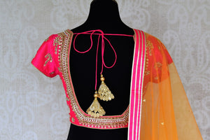Leave them spellbound as you show up in this jaw-dropping white chanderi silk lehenga accompanied with a stunning hot pink zardosi embroidered blouse. Complete the look with the orange sequinned net dupatta with pink border. Shop Indian dress, lehenga choli, ikkat sari online or visit Pure Elegance store, USA.-blouse back