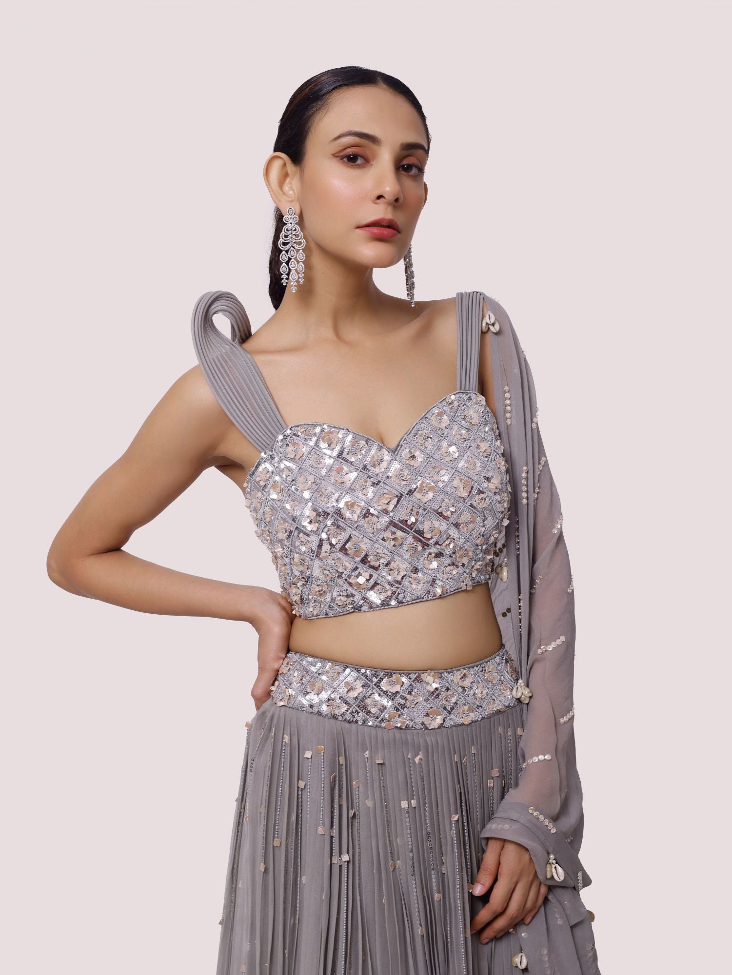 Buy a beautiful grey strappy sleeves lehenga featuring mirror work. The lehenga is perfect for weddings, and sangeet parties. Shop online from Pure Elegance.