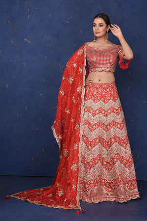 Buy red embroidered off-shoulder lehenga online in USA with dupatta, Be the center of attraction on festive occasions in beautiful designer suits, dresses, lehengas, designer gowns, from Pure Elegance Indian fashion store in USA.-front