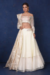 Shop elegant cream embroidered off-shoulder designer lehenga online in USA with dupatta. Set fashion goals on special occasions in exclusive designer lehengas, Indian suits, Anarkali dresses, designer gowns, bridal lehengas from Pure Elegance Indian fashion store in USA.-full view