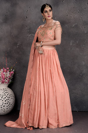 Shop beautiful peach off-shoulder designer lehenga online in USA with attached dupatta. Set a fashion statement at parties in designer Indian suits, Anarkali suits, designer lehengas, gowns, Indowestern dresses from Pure Elegance Indian fashion store in USA.-side