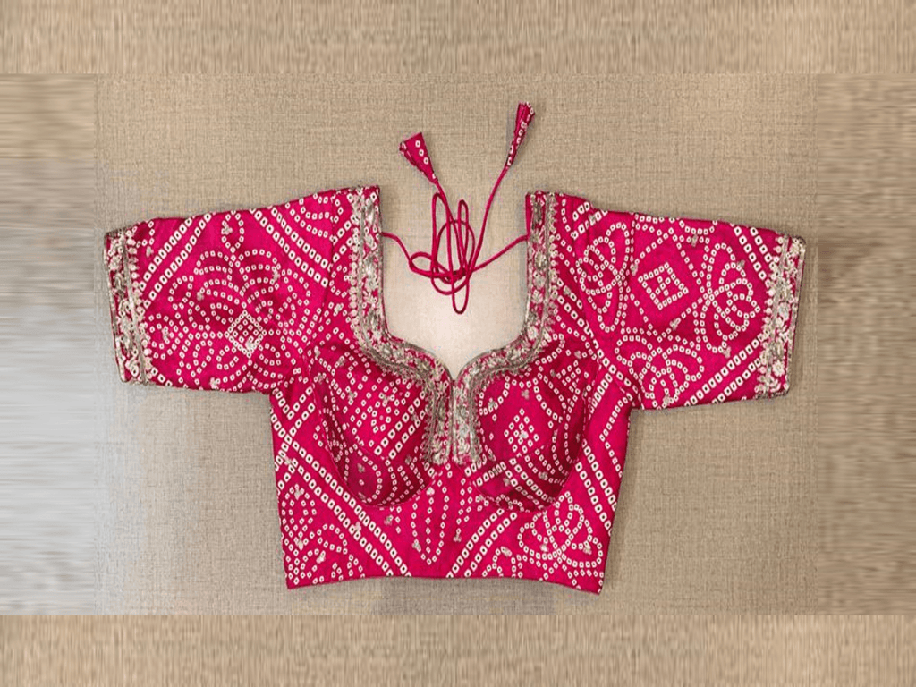 Buy a touch of serenity to your festive ethnic look with this soothing pink blouse. Crafted in silk with bhandhej print and sequin embroidery on the neck, it is embellished with 3/4th sleeves, hook closure, and tie-up at the back.  Buy this designer blouse in the USA from Pure Elegance. - front view