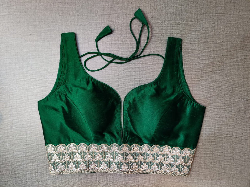 Buy beautiful bottle green sleeveless saree blouse online in USA with lace border. Elevate your Indian ethnic saree looks with beautiful readymade saree blouse, embroidered saree blouses, Banarasi saree blouse, designer saree blouses from Pure Elegance Indian fashion store in USA.-front