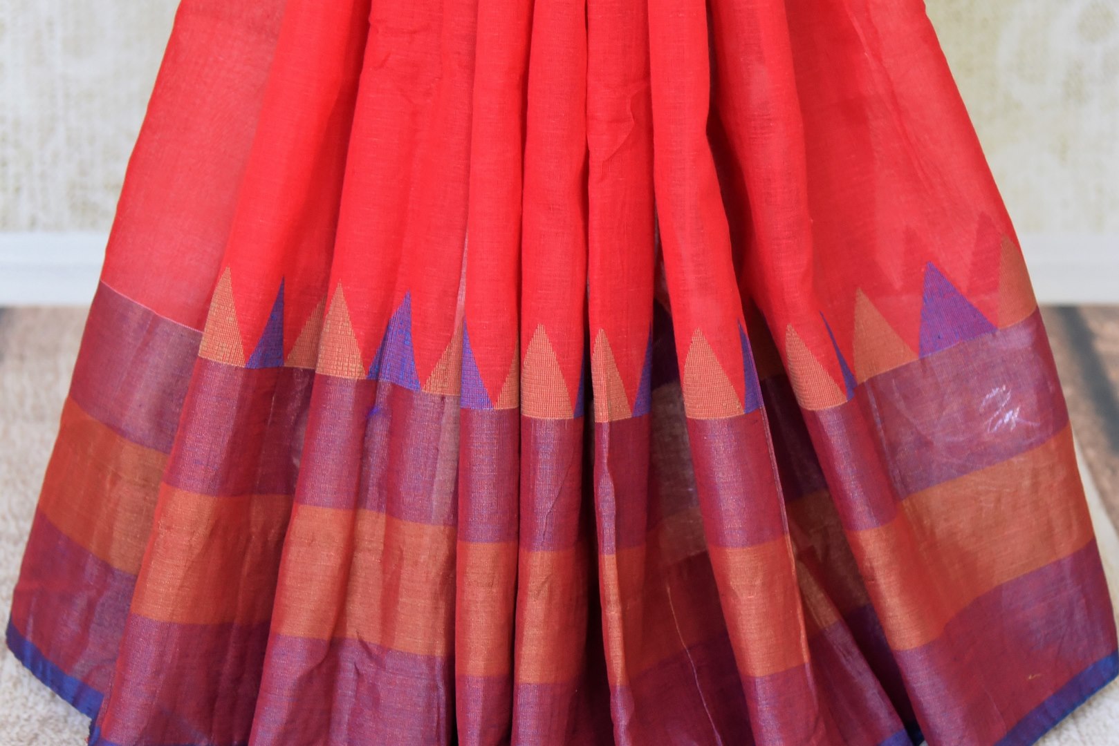 Shop red linen saree online in USA with purple border from Pure Elegance online store. Visit our exclusive Indian clothing store in USA and get floored by a range of exquisite Indian sarees, handloom sarees, silk sarees, Indian jewelry and much more to complete your ethnic look.-pleats