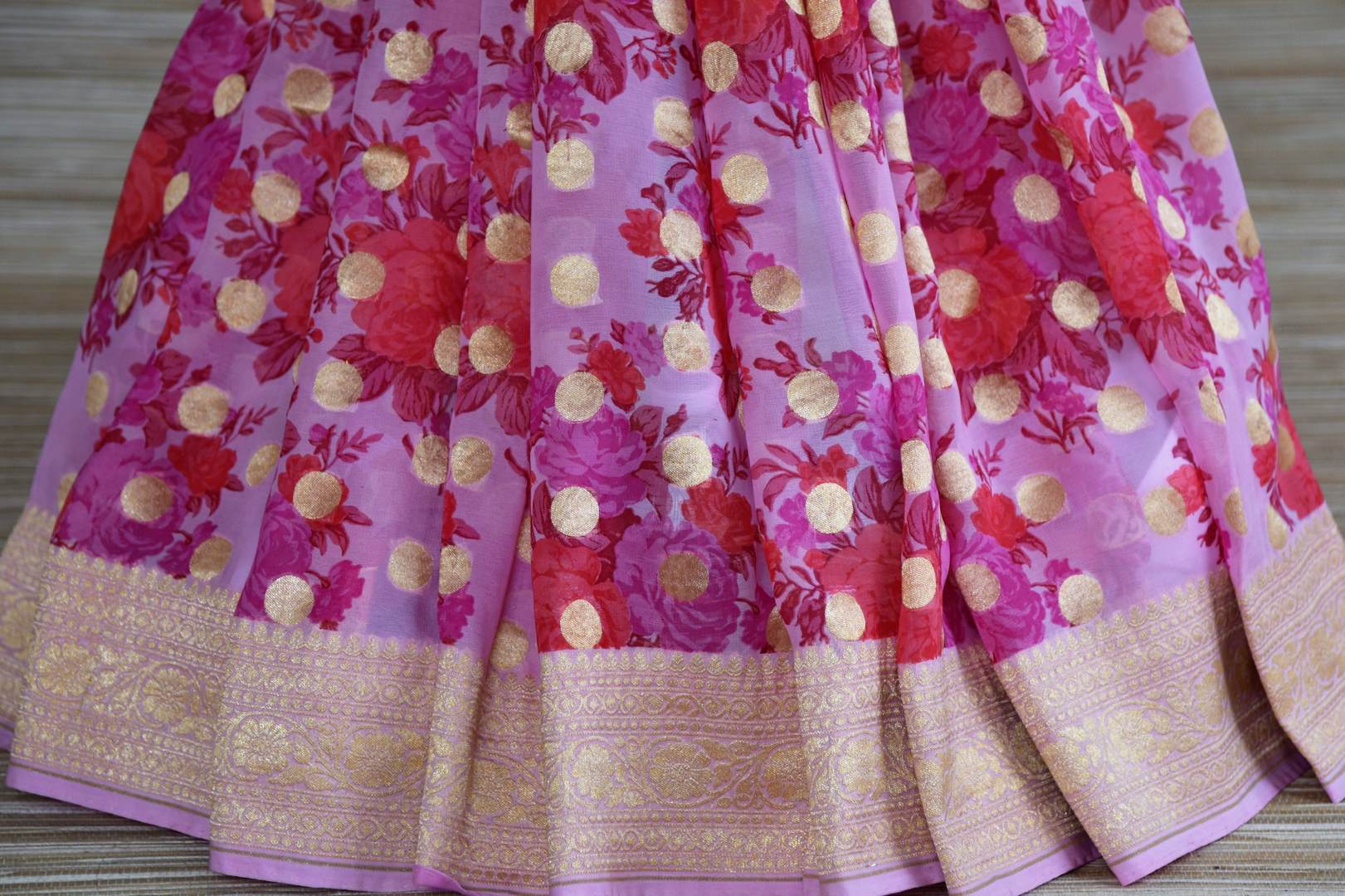 Shop pink floral georgette Banarasi saree online in USA with zari border. Radiate traditional charm with beautiful Banarasi sarees from Pure Elegance Indian clothing store in USA. Choose from a variety of Banarasi silk sarees, Banarasi georgette sarees, Banarasi tussar saris for special occasions.-pleats