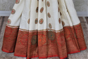 Buy off-white muga Banarasi sari online in USA with red antique zari floral border. Keep your ethnic style updated with latest designer sarees, handloom sarees, pure silk sarees from Pure Elegance Indian fashion store in USA.-pleats