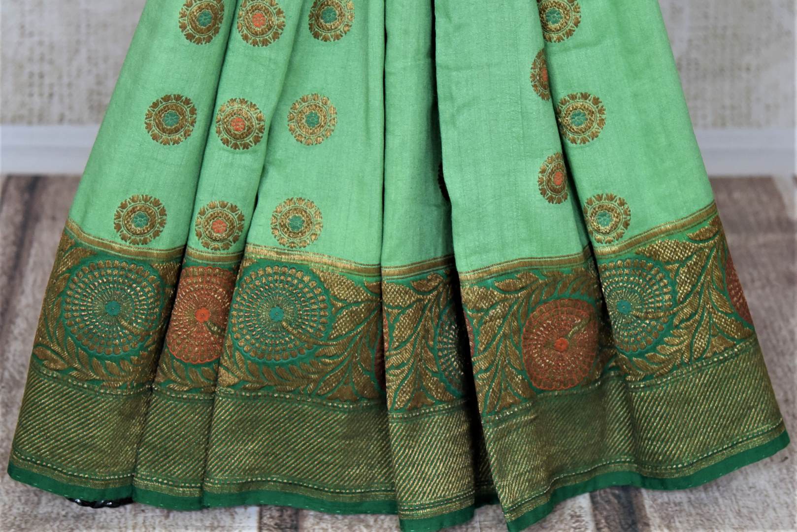 Buy pastel green muga Banarasi sari online in USA with dark green antique zari floral border. Keep your ethnic style updated with latest designer sarees, handloom sarees, pure silk sarees from Pure Elegance Indian fashion store in USA.-pleats