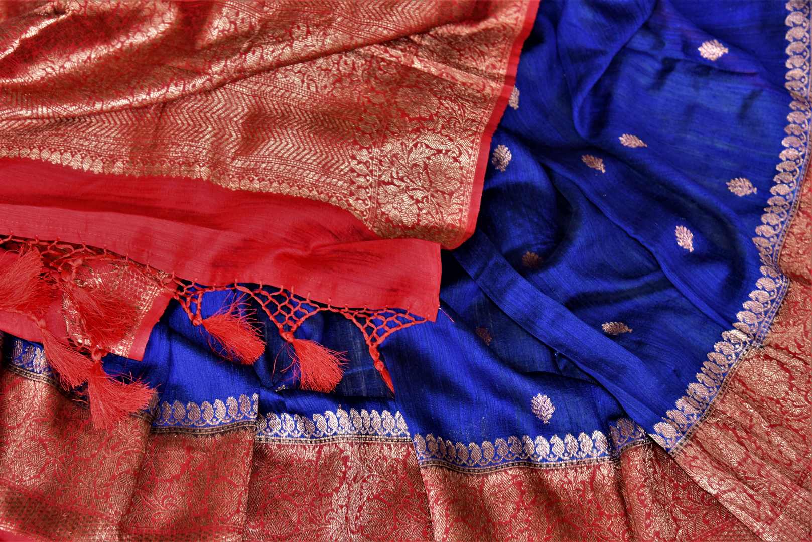 Shop indigo blue tussar Banarasi saree online in USA with zari buta and red antique zari border. Choose tasteful handloom saris for special occasions from Pure Elegance. Our exclusive Indian fashion store has a myriad of exquisite pure silk saris, tussar sarees, Banarasi sarees for Indian women in USA.-details