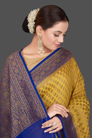 Buy stunning yellow georgette Banarasi saree online in USA with blue zari border. Get ready for festive occasions and weddings in tasteful designer sarees, Banarasi sarees, handwoven sarees from Pure Elegance Indian clothing store in USA.-closeup