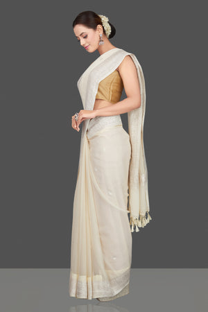 Shop cream georgette chiffon sari online in USA with silver zari border. Go for stunning Indian designer sarees, georgette sarees, handwoven sarees, embroidered sarees for festive occasions and weddings from Pure Elegance Indian clothing store in USA.-side