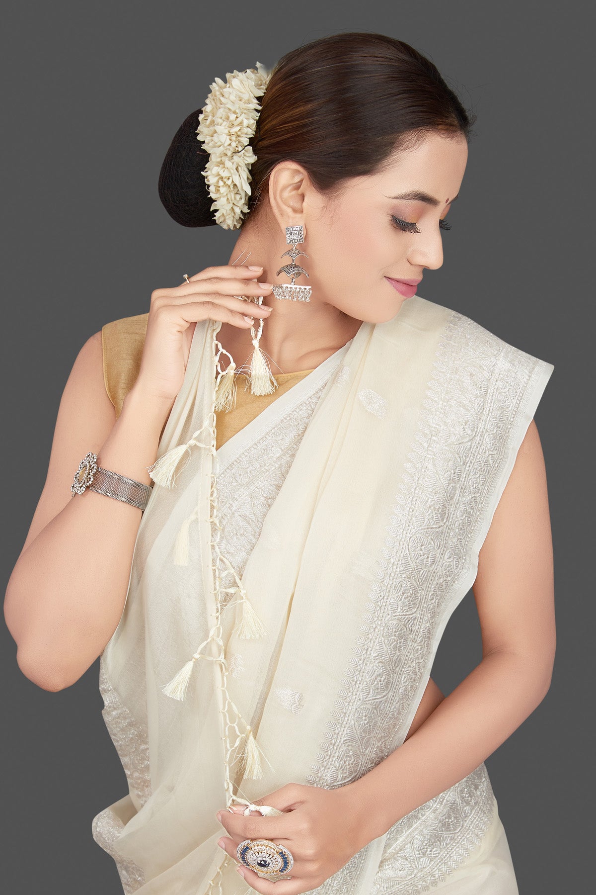 Shop cream georgette chiffon sari online in USA with silver zari border. Go for stunning Indian designer sarees, georgette sarees, handwoven sarees, embroidered sarees for festive occasions and weddings from Pure Elegance Indian clothing store in USA.-closeup