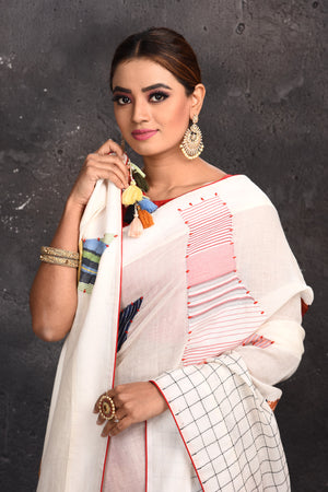 Buy beautiful off-white applique linen sari online in USA with check border. Keep your ethnic wardrobe up to date with latest designer sarees, pure silk sarees, handwoven sarees, tussar silk sarees, embroidered sarees from Pure Elegance Indian saree store in USA.-closeup