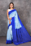 Shop this elegant offwhite-blue handloom shibori tussar saree online in USA which is handcrafted from fine silk tussar fabric, this tie and dye saree brings out the nature of flow. You can pair this beautiful shibori print with minimal jewellery for a casual day outfit. Add this plain shibori saree to your collection from Pure Elegance Indian fashion store in USA.- Full view.