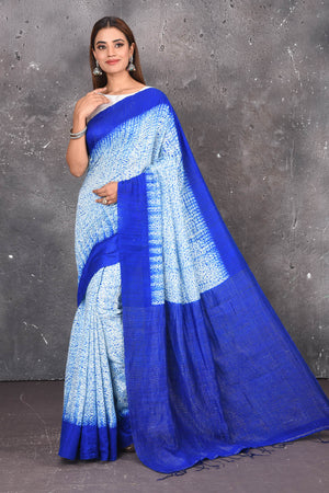 Shop this elegant offwhite-blue handloom shibori tussar saree online in USA which is handcrafted from fine silk tussar fabric, this tie and dye saree brings out the nature of flow. You can pair this beautiful shibori print with minimal jewellery for a casual day outfit. Add this plain shibori saree to your collection from Pure Elegance Indian fashion store in USA.-Full view with open pallu.