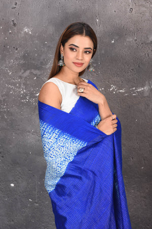 Shop this elegant offwhite-blue handloom shibori tussar saree online in USA which is handcrafted from fine silk tussar fabric, this tie and dye saree brings out the nature of flow. You can pair this beautiful shibori print with minimal jewellery for a casual day outfit. Add this plain shibori saree to your collection from Pure Elegance Indian fashion store in USA.-Close up.