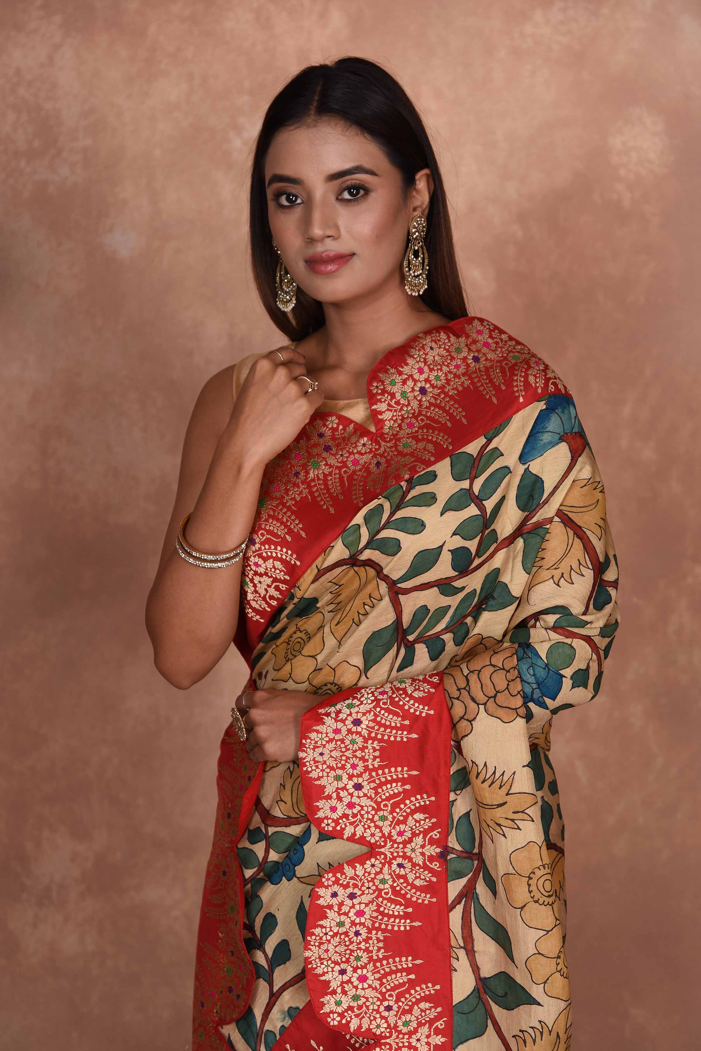 Buy beige Kalamkari Kanjivaram sari online in USA with red scalloped border. Keep your ethnic wardrobe up to date with latest designer sarees, pure silk saris, Kanchipuram silk sarees, handwoven sarees, tussar silk saris, embroidered sarees, soft silk sarees, Kora silk sarees from Pure Elegance Indian saree store in USA.-closeup