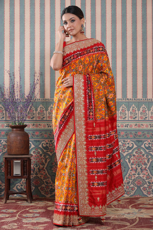 Buy orange Patola silk sari online in USA with red embroidered border. Make a fashion statement at weddings with stunning designer sarees, embroidered sarees with blouse, wedding sarees, handloom sarees from Pure Elegance Indian fashion store in USA.-front