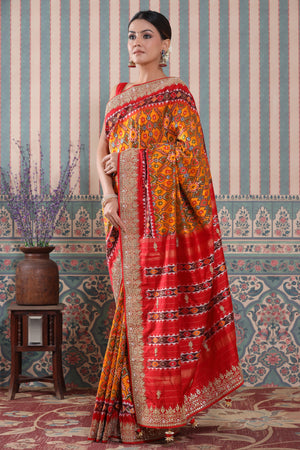 Buy orange Patola silk sari online in USA with red embroidered border. Make a fashion statement at weddings with stunning designer sarees, embroidered sarees with blouse, wedding sarees, handloom sarees from Pure Elegance Indian fashion store in USA.-pallu
