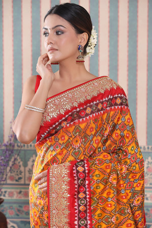 Buy orange Patola silk sari online in USA with red embroidered border. Make a fashion statement at weddings with stunning designer sarees, embroidered sarees with blouse, wedding sarees, handloom sarees from Pure Elegance Indian fashion store in USA.-closeup