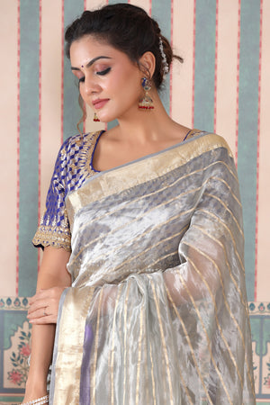 Buy grey striped tissue silk sari online in USA with blue saree blouse. Make a fashion statement at weddings with stunning designer sarees, embroidered sarees with blouse, wedding sarees, handloom sarees from Pure Elegance Indian fashion store in USA.-closeup