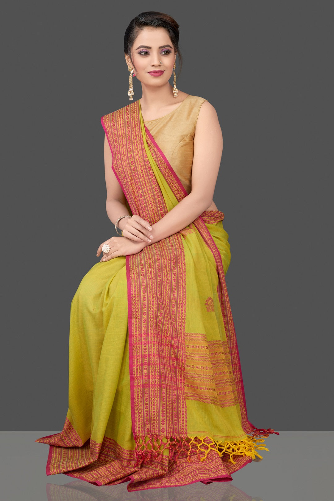 Shop beautiful pista green cotton saree online in USA with pink Assam design pallu. Flaunt Indian fashion in USA with a stunning collection of handwoven sarees, cotton sarees, pure silk sarees, designer saris in USA from Pure Elegance Indian saree store in USA.-sitting