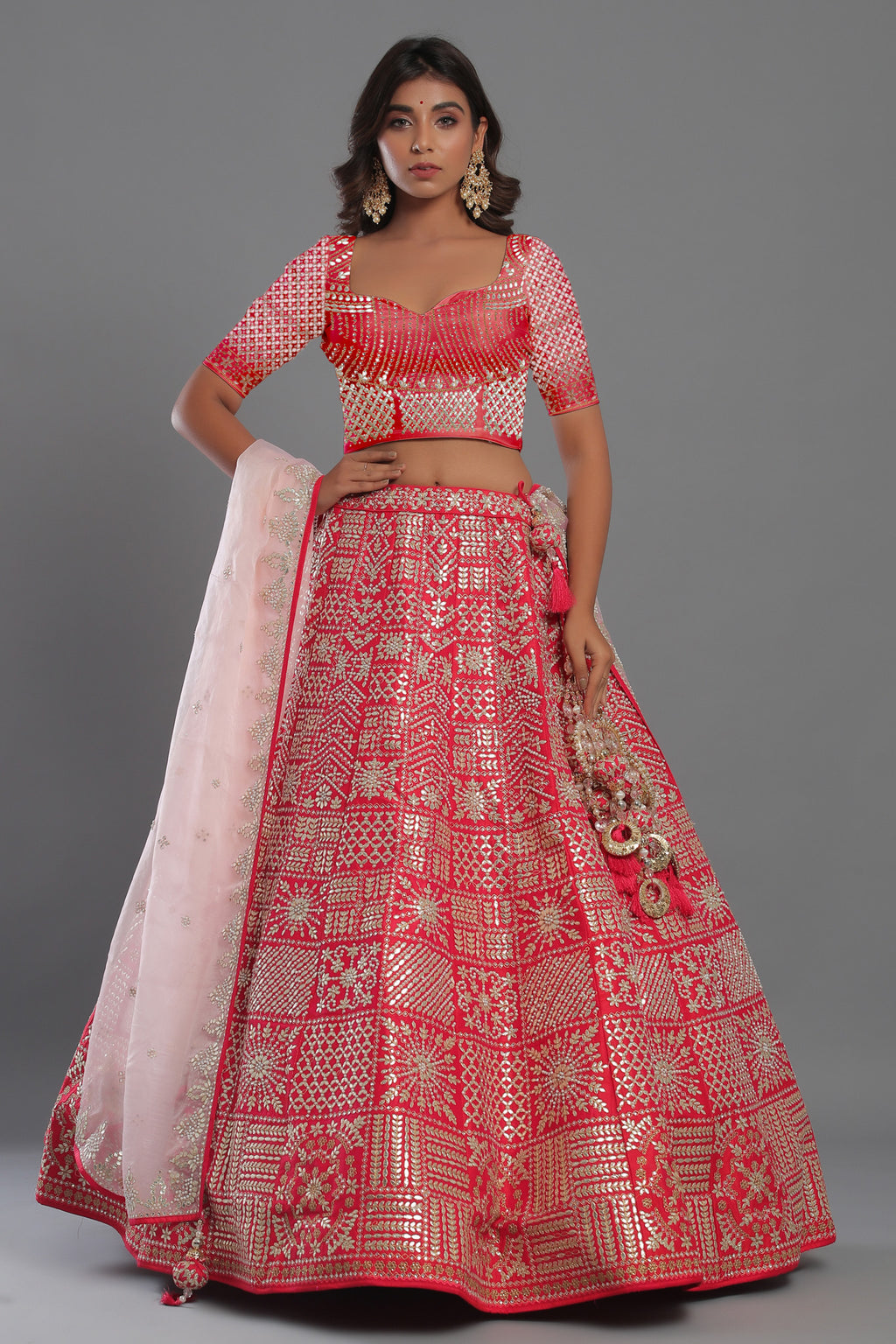 Shop red heavily silver embroidered lehenga with net dupatta. The lehenga is perfect for a wedding party. It is crafted in silk with intrinsic zari embroidery on lehenga and blouse all over, tassels on a dupatta, with beautiful heavy tassles attached on the lehenga . Shop online from Pure Elegance.