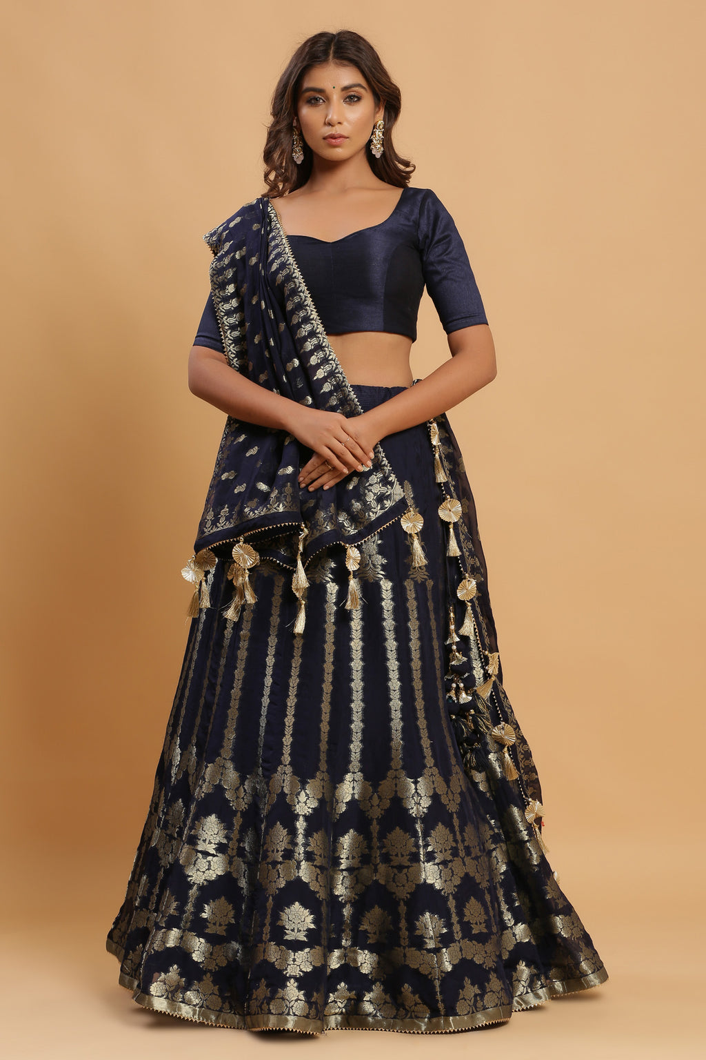 Shop navy zari embroidered lehenga with attached dupatta. It is crafted in silk with intrinsic zari embroidery on the lehenga and solid blouse tassels on a dupatta, with beautiful heavy tassels attached to the lehenga. Shop online from Pure Elegance.