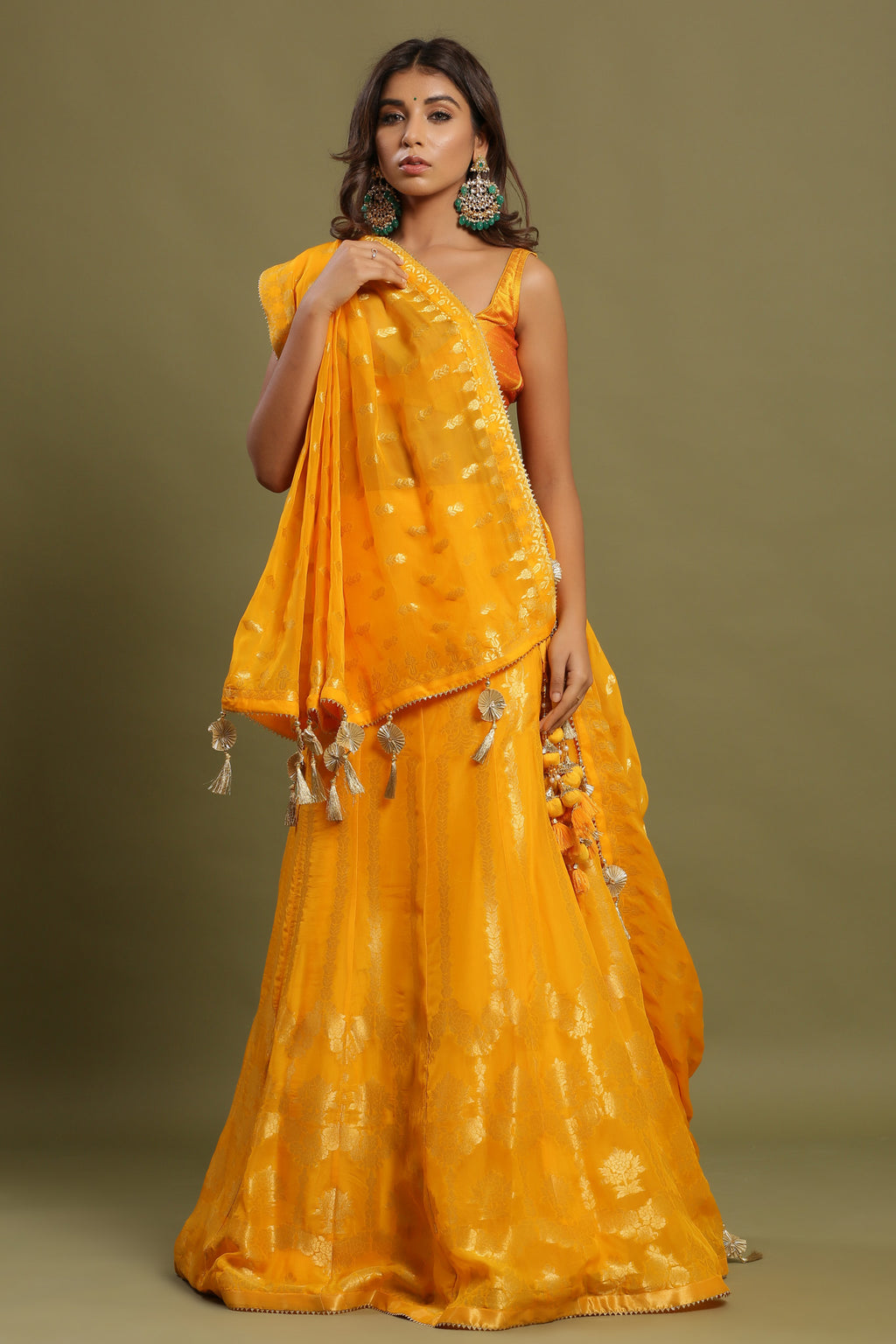 Shop yellow zari embroidered lehenga with attached dupatta. It is crafted in silk with intrinsic zari embroidery on the lehenga and solid blouse tassels on a dupatta, with beautiful heavy tassels attached to the lehenga. Shop online from Pure Elegance.