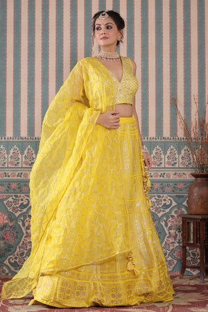Shop a yellow lehenga set featuring a heavy Zari Embroidered Silk Lehenga Set. It comes with a beautiful V-neck blouse and zip closure. It has tassels attached to the lehenga. Pair it with beautiful jewelry to enhance your look. Shop online from Pure Elegance.