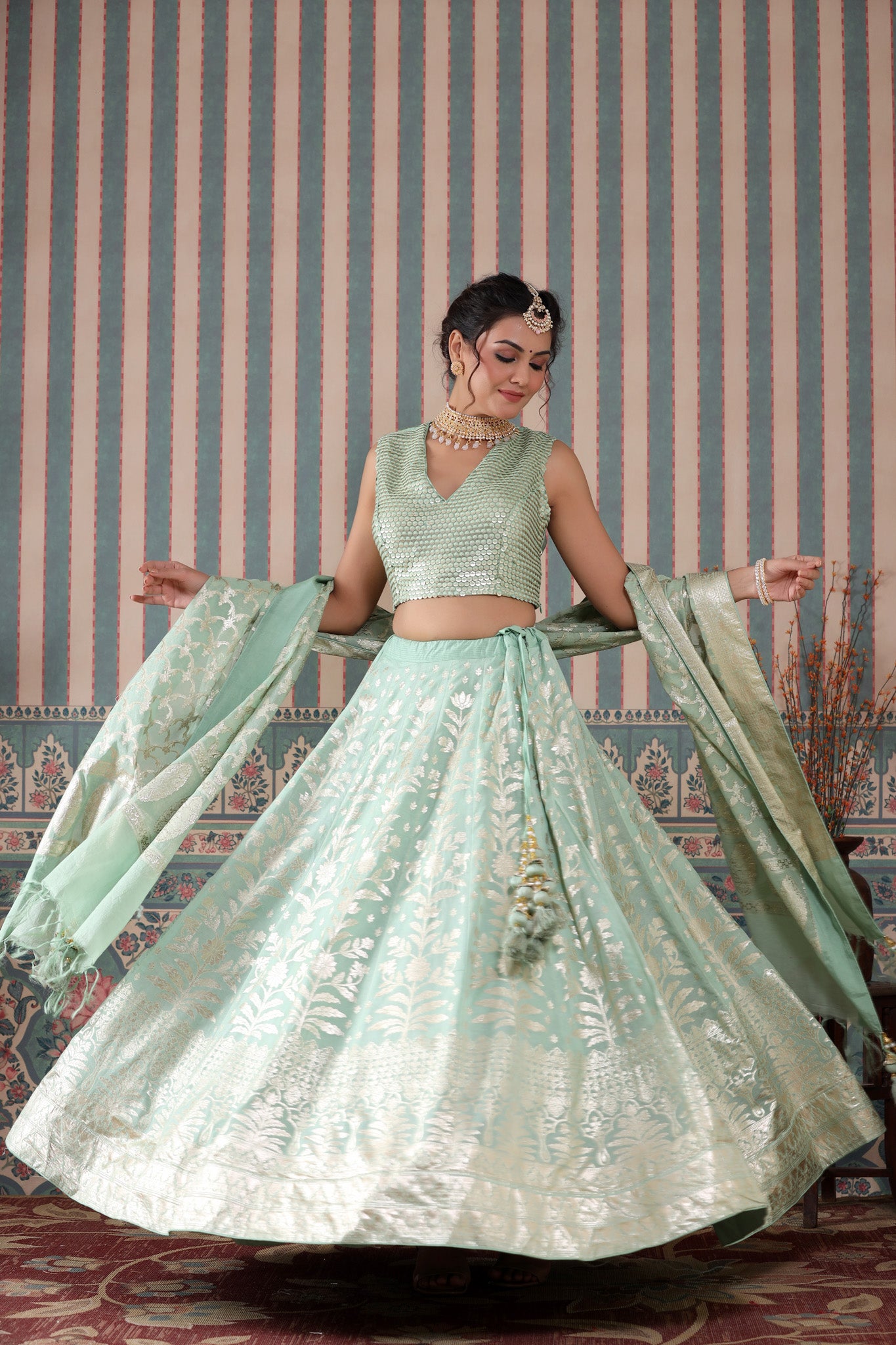 Shop a turquoise lehenga set featuring a floral zari embroidered silk lehenga set. It comes with a beautiful V-neck blouse and zip closure. It has tassels attached to the lehenga. Pair it with beautiful jewelry to enhance your look. Shop online from Pure Elegance.