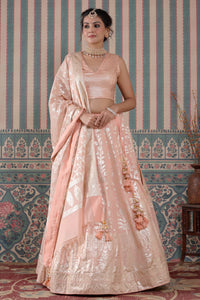 Shop a peach lehenga set featuring a floral zari embroidered silk lehenga set. It comes with a beautiful V-neck blouse and zip closure. It has tassels attached to the lehenga. Pair it with beautiful jewelry to enhance your look. Shop online from Pure Elegance.