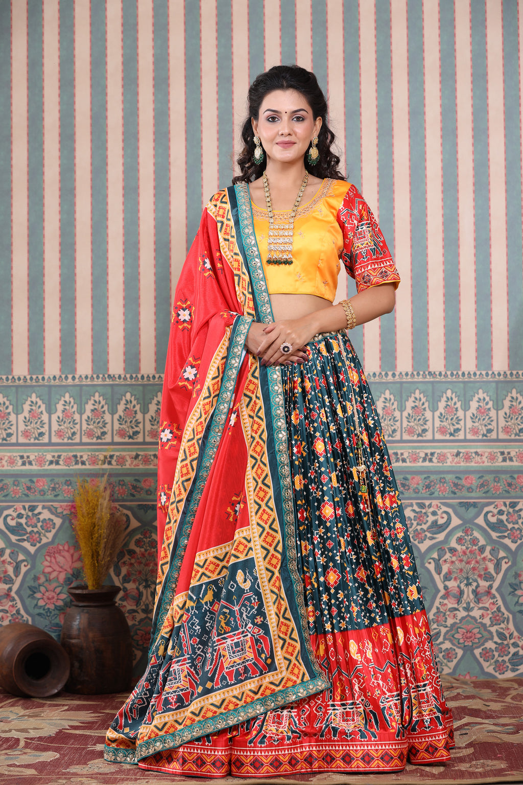 Shop a teal blue multicolor lehenga set featuring bhandhej printed silk lehenga set. It comes with a beautiful yellow blouse, gotta pati work red dupatta. Pair it with beautiful jewelry to enhance your look. Shop online from Pure Elegance.