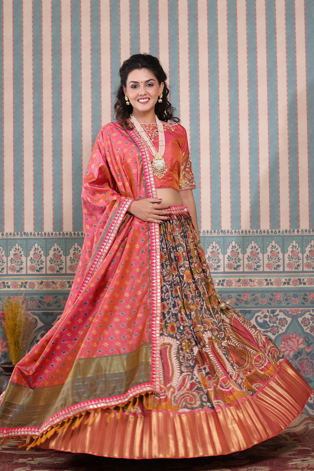 Shop a pink floral printed lehenga set featuring gota patti work and a silk dupatta set. It comes with a beautiful pink blouse embroidered with gota patti work. Pair it with beautiful jewelry to enhance your look. Shop online from Pure Elegance.