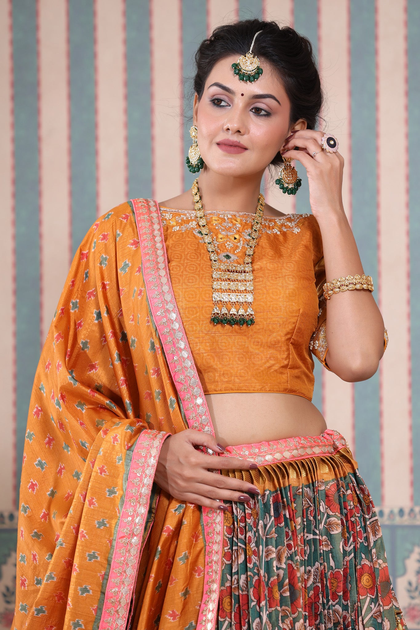 Shop a mustard floral printed lehenga set featuring gota patti work and a silk dupatta set. It comes with a beautiful mustard blouse embroidered with gota patti work. Pair it with beautiful jewelry to enhance your look. Shop online from Pure Elegance.