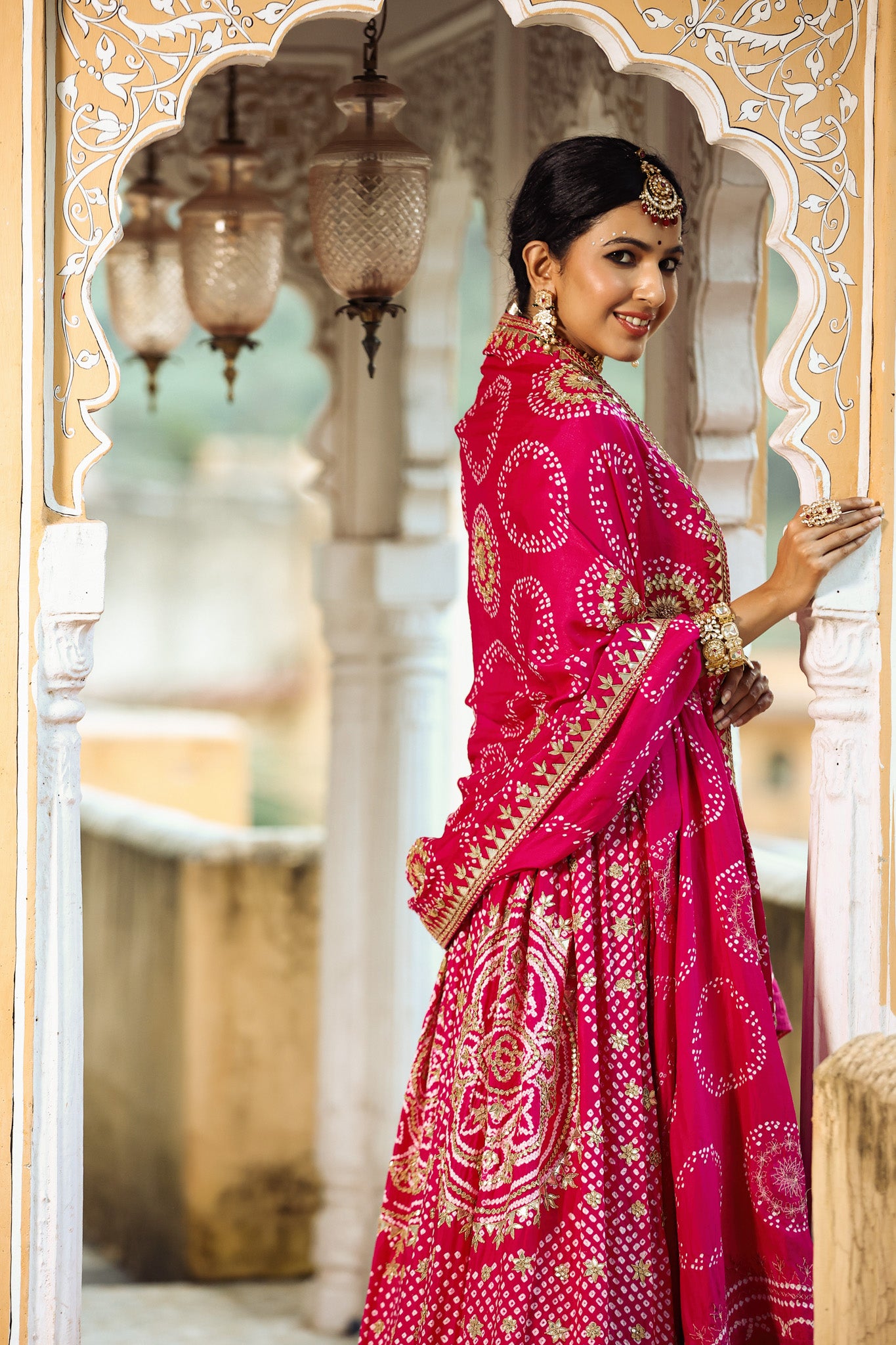 Shop a Pink bandhej print beautiful lehenga set with gota patti work and a long tassel attached to the lehenga. it comes with a pink blouse with front embroidery, hook closure, and tie-up at the back. Pair it with beautiful Rajasthani jewelry to enhance your look. Shop online from Pure Elegance.
