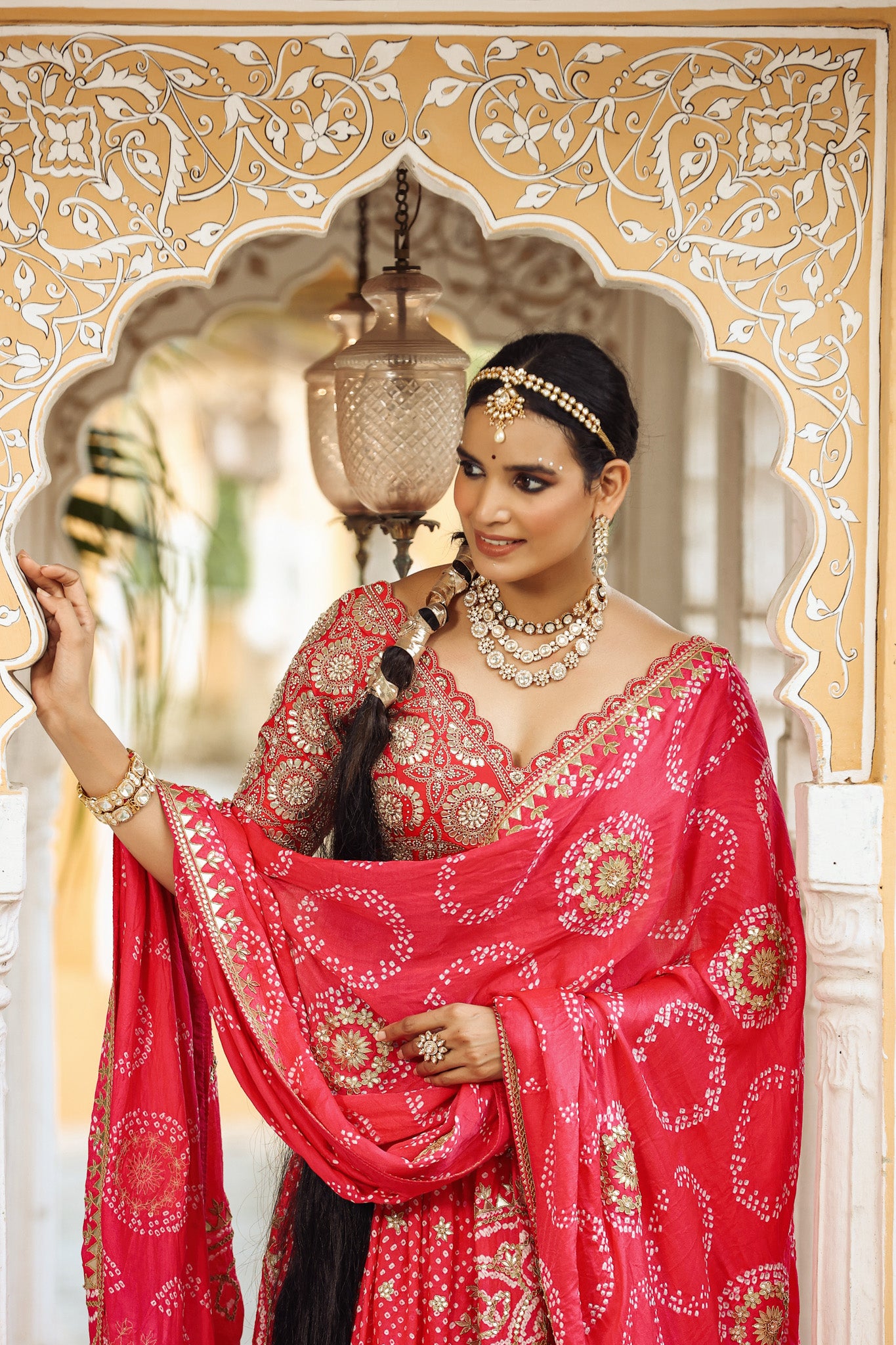 Shop a pink bandhej print beautiful lehenga set with gota patti work and long tassel attached on the lehenga. it comes with a pink blouse with heavy embroidery, hook closure, and tie-up at the back. Pair it with beautiful Rajasthani jewelry to enhance your look. Shop online from Pure Elegance.