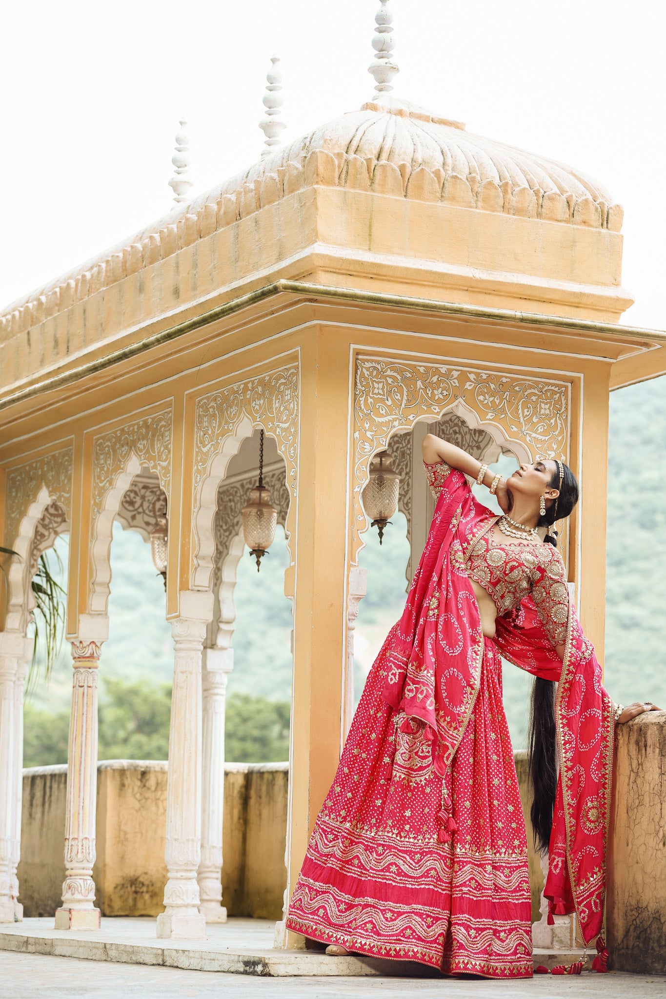 Shop a pink bandhej print beautiful lehenga set with gota patti work and long tassel attached on the lehenga. it comes with a pink blouse with heavy embroidery, hook closure, and tie-up at the back. Pair it with beautiful Rajasthani jewelry to enhance your look. Shop online from Pure Elegance.
