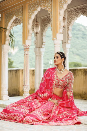 Shop a pink bandhej print beautiful lehenga set with gota patti work and long tassel attached on the lehenga. it comes with a pink blouse with heavy embroidery, hook closure, and tie-up at the back. Pair it with beautiful Rajasthani jewelry to enhance your look. Shop online from Pure Elegance.