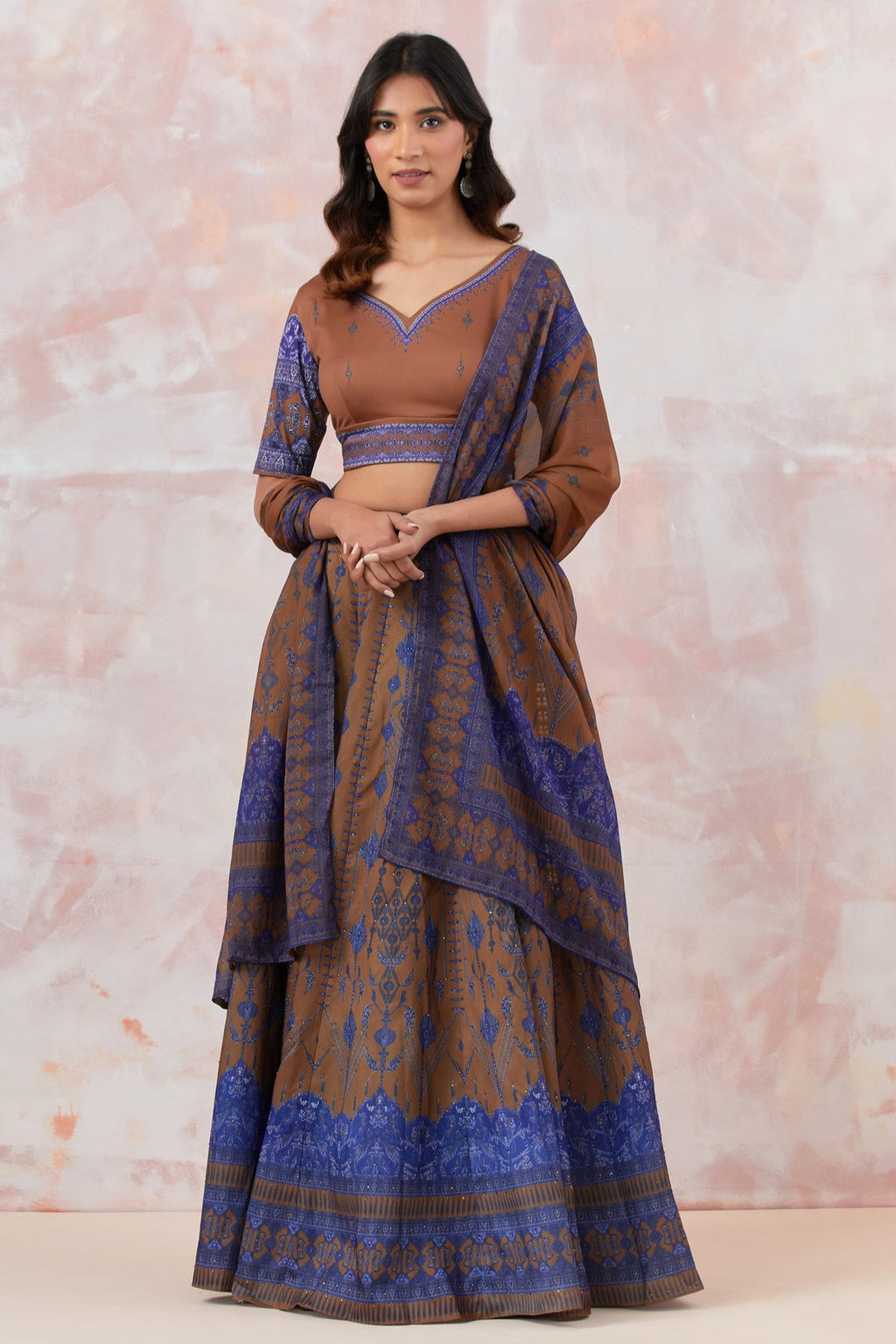 Shop a beige printed lehenga with a contrasting printed blouse dupatta. Dazzle on weddings and special occasions with exquisite Indian designer dresses, sharara suits, Anarkali suits, bridal lehengas, and sharara suits from Pure Elegance Indian clothing store in the USA. Shop online from Pure Elegance.