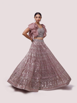 Shop this pink lehenga with ruffle sleeves blouse featuring sequin, mirror and pearl work. Dazzle on weddings and special occasions with exquisite Indian designer dresses, sharara suits, Anarkali suits, bridal lehengas, and sharara suits from Pure Elegance Indian clothing store in the USA. Shop online from Pure Elegance.
