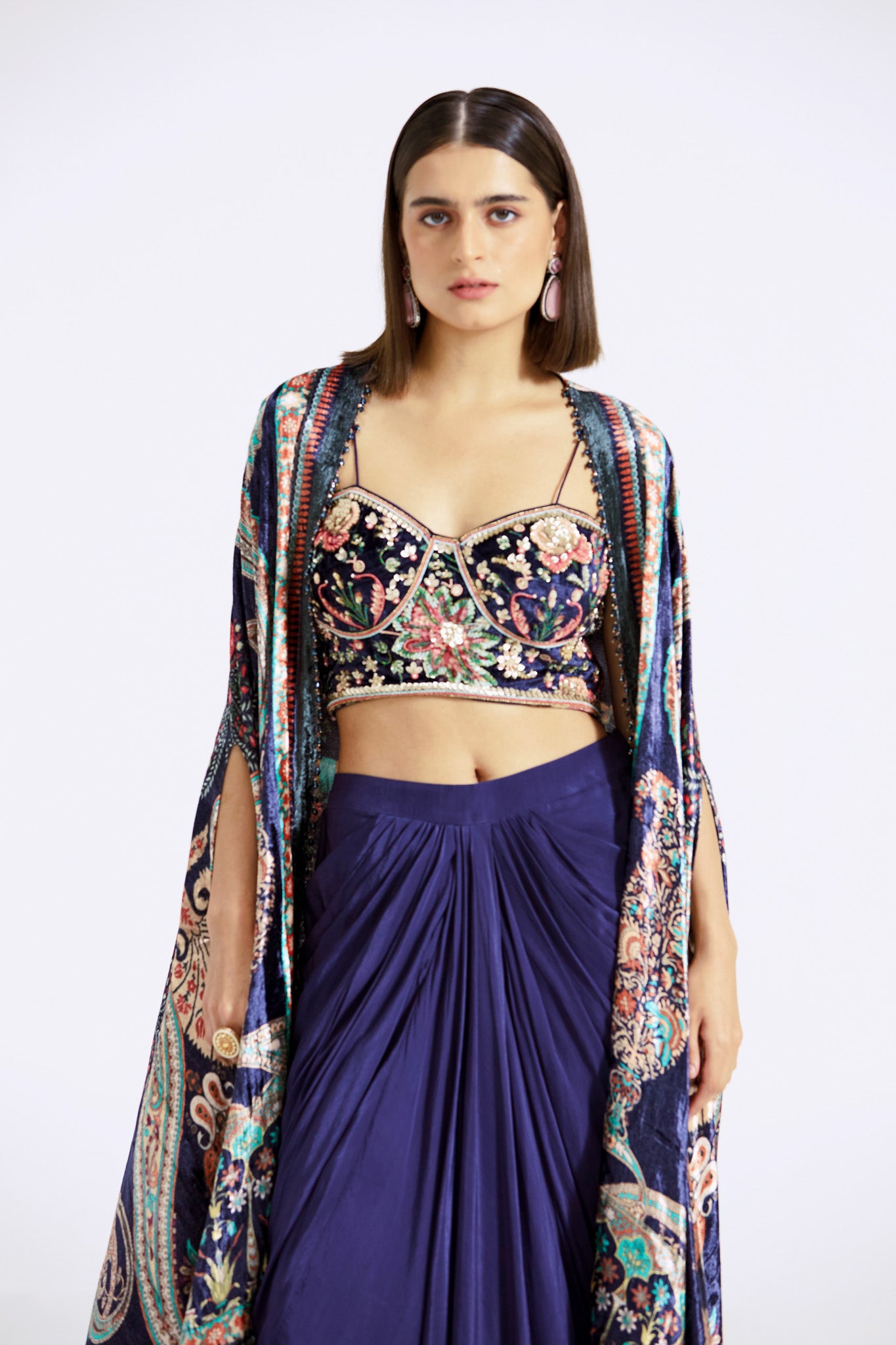 Buy blue velvet and crepe draped skirt set online in USA with printed cape. Shop the best and latest designs in embroidered sarees, designer sarees, Anarkali suit, lehengas, sharara suits for weddings and special occasions from Pure Elegance Indian fashion store in USA.-closeup