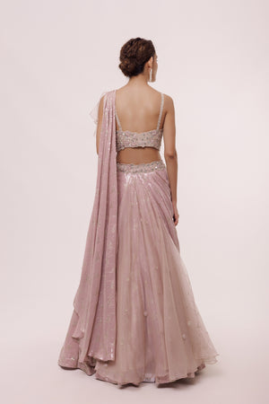 Shop the look your best on wedding occasions in this old rose pink silver sequinned lehenga with a sleeveless cut dana work, heavy embroidered blouse & dupatta. Dazzle on weddings and special occasions with exquisite Indian designer dresses, sharara suits, Anarkali suits, bridal lehengas, and sharara suits from Pure Elegance Indian clothing store in the USA. Shop online from Pure Elegance.