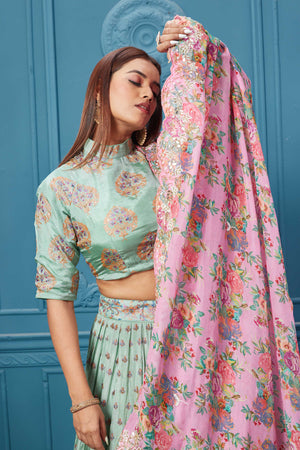 Buy a pastel green embroidered lehenga with a contrasting pink floral dupatta online in the USA. Look royal at weddings and festive occasions in exquisite designer sarees, gowns, lehngas, Anarkali, and suits Pure Elegance Indian saree store in the USA. 